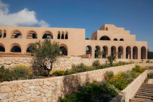 a building with a stone wall in front of it at Nômade Temple Ibiza - New Opening in Portinatx +112 photos