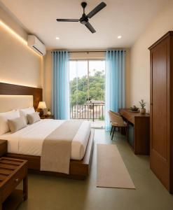 a bedroom with a bed and a desk and a window at Hotel Velmont Kandy in Kandy