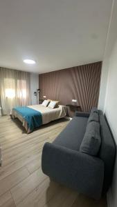 a bedroom with a bed and a couch at Hostal Casa Amalia in Teruel
