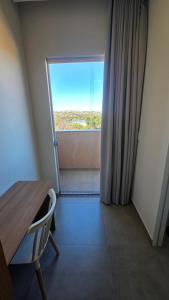 a room with a table and a door with a window at Lagoa Suítes in Lagoa Santa