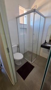 a bathroom with a toilet and a glass shower at Lagoa Suítes in Lagoa Santa
