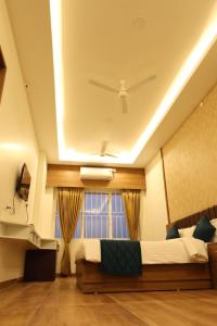a bedroom with a large bed and a window at Skvr Grand in Theni