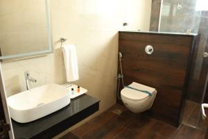 a bathroom with a white sink and a toilet at Skvr Grand in Theni