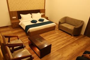 a small bedroom with a bed and a chair at Skvr Grand in Theni