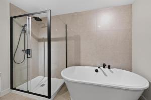 a bathroom with a white tub and a glass shower at 200-214 - Le Niveau 2 in Beaupré +14 photos