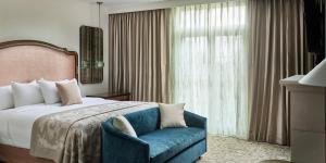 a hotel room with a bed and a blue chair at Mirbeau Inn & Spa Beacon in Beacon +43 photos