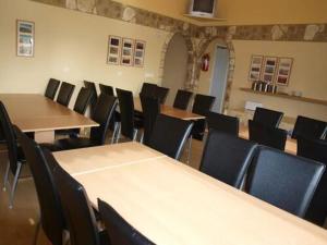 a room with rows of tables and chairs at Guesthouse Hof in Hofgarðar
