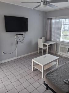 a living room with a bed and a table and a tv at Tropical Sky Ranch Motel in Clearwater Beach