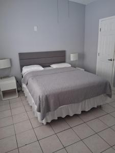 a bedroom with a large bed and a tiled floor at Tropical Sky Ranch Motel in Clearwater Beach +14 photos