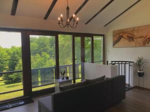 a living room with a couch and large windows at Empyrean House in Dišnik