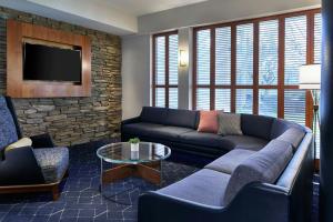 a living room with a couch and a tv at Courtyard Rochester Brighton in Rochester
