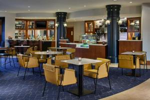 a restaurant with tables and chairs and a bar at Courtyard Rochester Brighton in Rochester