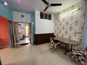 a living room with a table and a bedroom at Peaceful Living in Kolkata