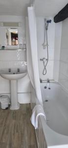 a bathroom with a tub and a sink and a toilet at The Poppy House in Bishops Castle