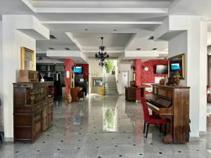 a living room with a piano and a red chair at WEST GATE free parking & wi-fi in Sutomore