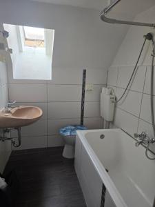 a bathroom with a tub and a toilet and a sink at Hotel-Restaurant am weißen Turm Self Check-in in Rothenburg ob der Tauber +65 photos