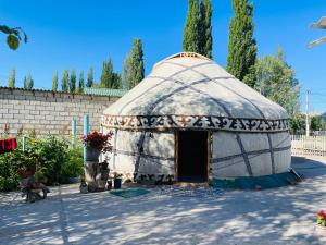 a yurt in a yard with a wall at Azem Guest House in Kasymbek