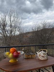 Eine Obstschale auf einem Holztisch auf einem Balkon in der Unterkunft BruD ԲՐՈՒԴ in Debed