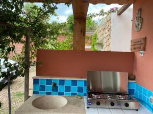 an outdoor kitchen with a stove and blue tiles at Stazzo La Foci vista Mare in Aglientu
