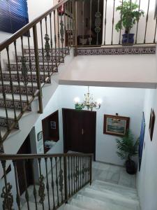 a staircase in a house with white walls and wooden railings at Hostal El Polígono in Lucena