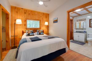 a bedroom with a large bed and a bathroom at Private Dock & Deck: Tranquil Dam Pond Cottage! in Augusta