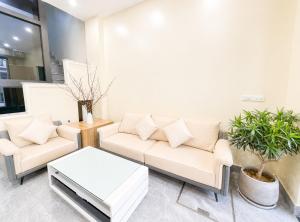 a living room with a couch and a table at Do Homestay vị trí trung tâm tại Ocean Park 2 in Cửu Cảo
