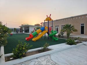 a playground with a slide in a yard at مزرعه فلج فارم Falaj-farm in Falaj al Mu‘allá