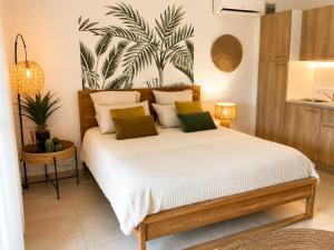 a bedroom with a bed with white sheets and green pillows at Kalista - Studio Luxueux - Anse Marcel in Saint Martin