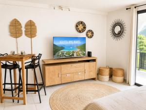 a living room with a tv and a table at Kalista - Studio Luxueux - Anse Marcel in Saint Martin