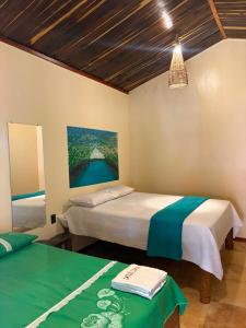 a bedroom with two beds and a painting on the wall at Point lanabarra in Amontada