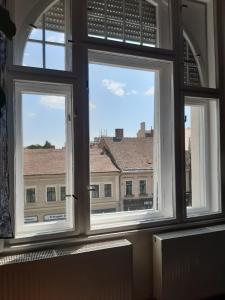 a window with three views of a building at The Stage Door Apartment in Debrecen +15 photos