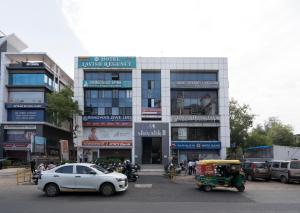 a white car parked in front of a building at Hotel Lavish Regency in Ahmedabad