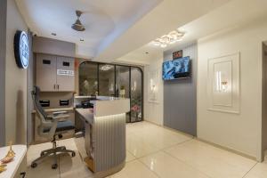 an office with a desk and a chair and a monitor at Hotel Lavish Regency in Ahmedabad