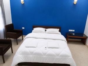 a bedroom with a large bed with a blue wall at Niru Buddha Hotel, Lumbini in Rummindei
