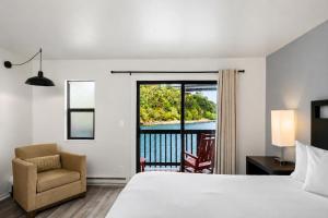 a hotel room with a bed and a chair and a window at Anchor Lodge in Fort Bragg