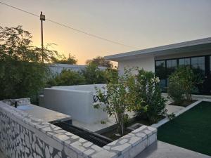 a house with a retaining wall and a garden at مزرعه فلج فارم Falaj-farm in Falaj al Mu‘allá