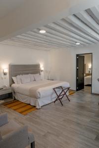 a bedroom with a large bed and a living room at Hotel La Morada in San Miguel de Allende