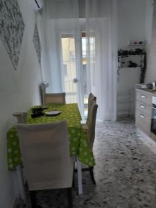 a kitchen with a table with a green table cloth on it at casa vacanza Lu Murajon in Dogliola +12 photos