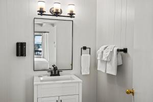 a white bathroom with a sink and a mirror at Anchor Lodge in Fort Bragg +62 photos
