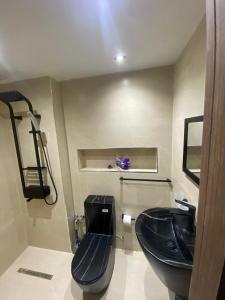 a bathroom with a black sink and a toilet at Bouchareb résidences in Quşaybat al Madyūnī