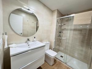a bathroom with a toilet and a sink and a shower at Residencial Junceda in Viveiro