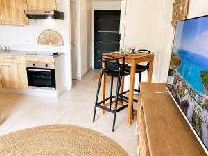 a kitchen with a table and a television in a room at Kalista - Studio Luxueux - Anse Marcel in Saint Martin