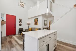 a kitchen with white cabinets and a red door at Quarry A21 in Whitefish +29 photos