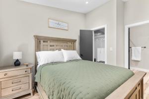 a bedroom with a bed with a green comforter and a dresser at Timber and Trail in Kimberling City +23 photos