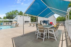 a table and chairs under a blue umbrella on a patio at Timber and Trail in Kimberling City