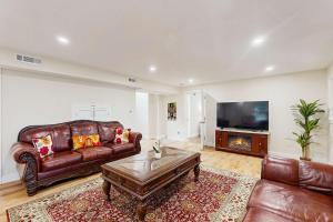 a living room with a leather couch and a tv at Pond Treasure in Sandwich