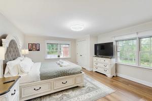 a white bedroom with a bed and a television at Pond Treasure in Sandwich +42 photos