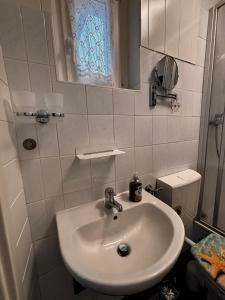 a white bathroom with a sink and a mirror at Idylle Ostsee in Buggenhagen