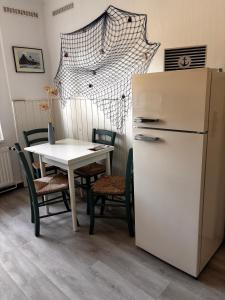a kitchen with a table and a white refrigerator at Idylle Ostsee in Buggenhagen