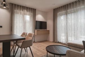 a living room with a table and chairs and a television at Egerner Chalet in Rottach-Egern
